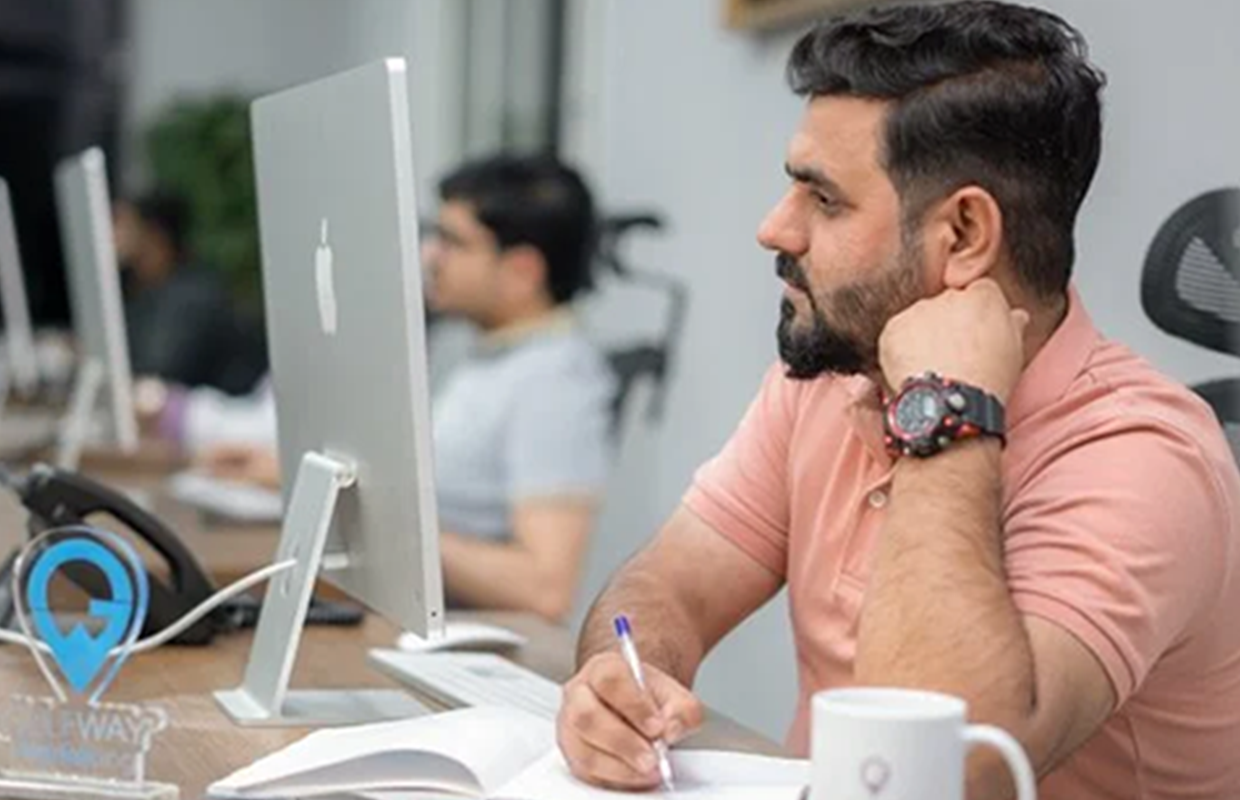 Gulf Way Auto Services IT professional with tablet in office, emphasizing digital expansion and software development.