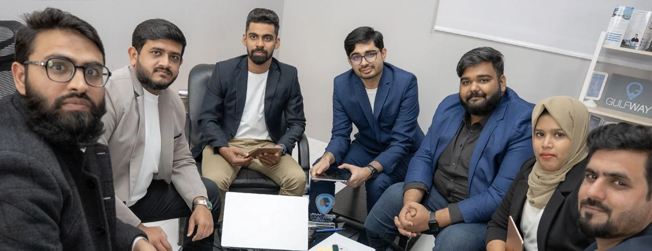 Gulf Way Auto Services Digital Marketing and IT team collaborating on a laptop, driving digital growth and innovation.